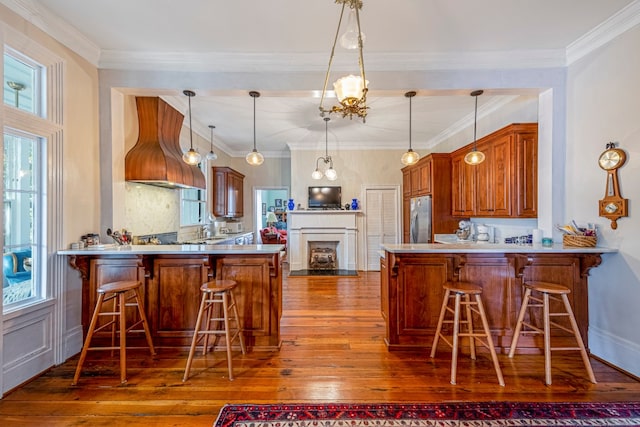 kitchen featuring dark hardwood / wood-style flooring, stainless steel refrigerator, pendant lighting, and kitchen peninsula