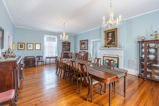 dining area with crown molding, dark hardwood / wood-style floors, and an inviting chandelier