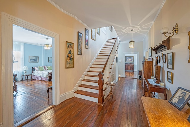 interior space featuring dark hardwood / wood-style floors, ornamental molding, and ceiling fan