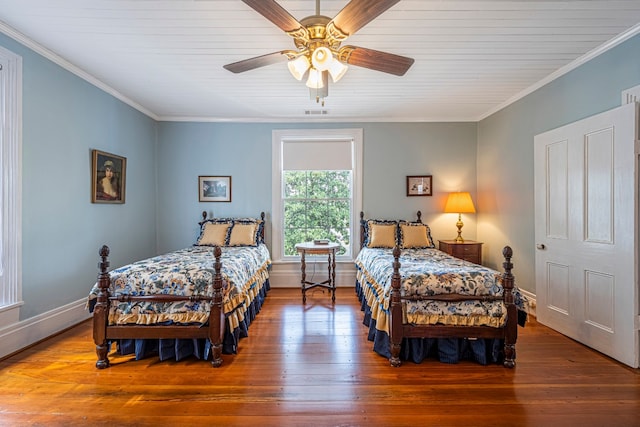 bedroom with ornamental molding, dark hardwood / wood-style flooring, and ceiling fan