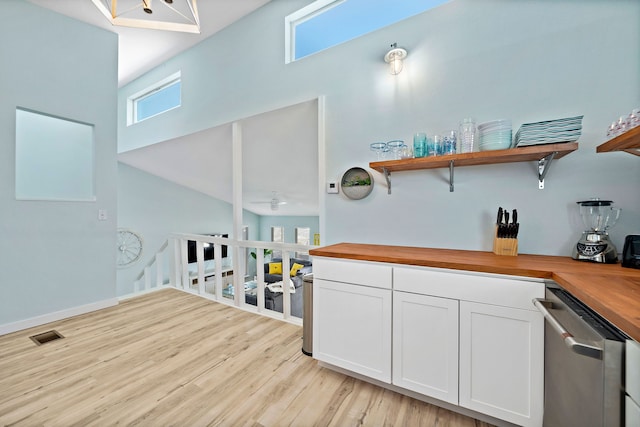 kitchen with butcher block countertops, white cabinetry, dishwasher, and light hardwood / wood-style flooring