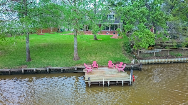 view of dock featuring a water view and a yard