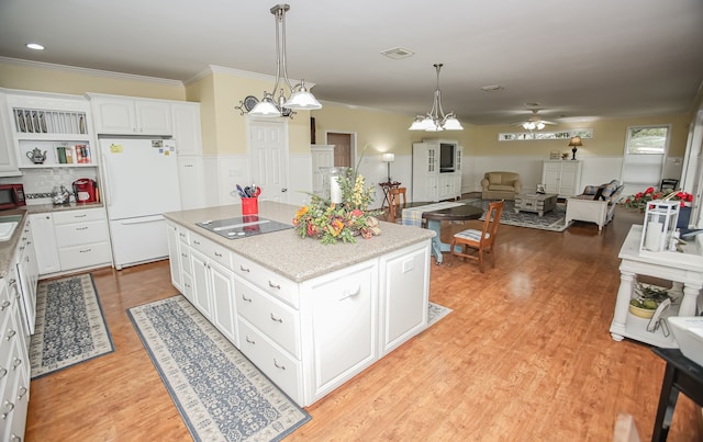 kitchen with white fridge, white cabinetry, a kitchen island, light hardwood / wood-style flooring, and ceiling fan with notable chandelier