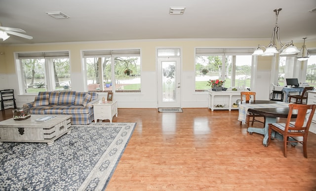 living room featuring ceiling fan, crown molding, and light hardwood / wood-style flooring