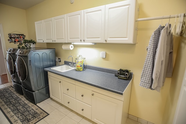 washroom with sink, washing machine and dryer, cabinets, and light tile floors