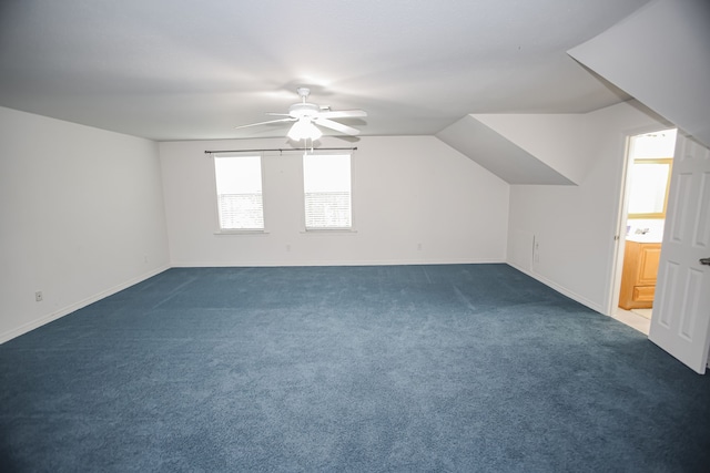 additional living space with ceiling fan, sink, dark colored carpet, and vaulted ceiling