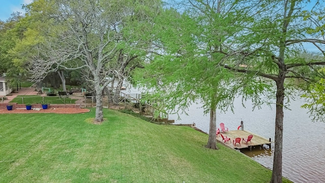 view of yard with a water view and a dock