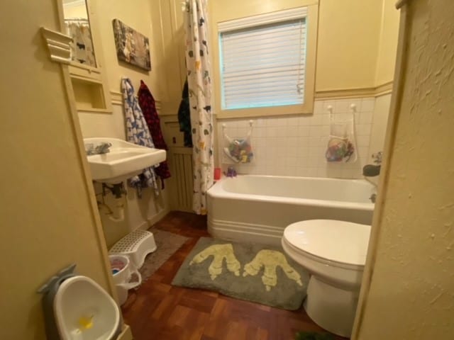 full bathroom featuring toilet, shower / tub combo with curtain, hardwood / wood-style floors, and sink