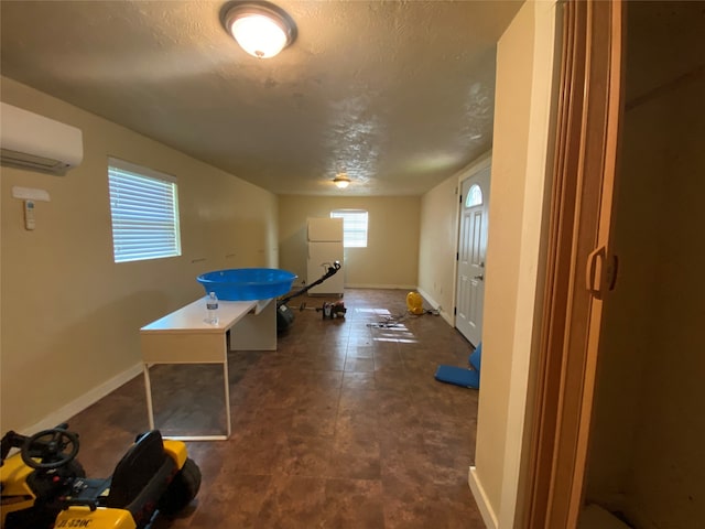 rec room with a wall mounted AC and dark tile floors