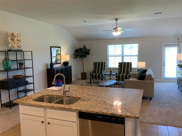 kitchen with dishwasher, sink, ceiling fan, and light stone countertops