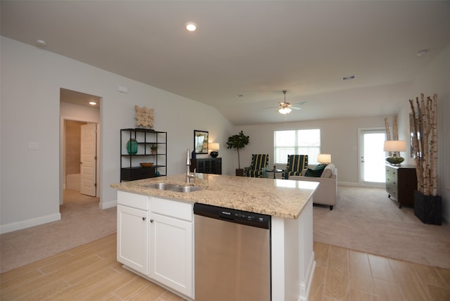 kitchen with a kitchen island with sink, sink, stainless steel dishwasher, light carpet, and white cabinetry