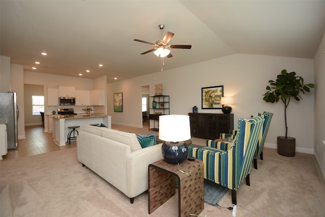 carpeted living room with sink, ceiling fan, and vaulted ceiling