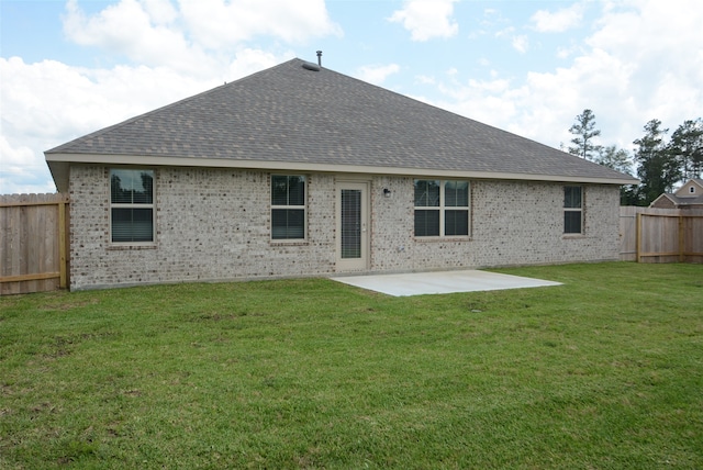 rear view of house with a patio and a lawn