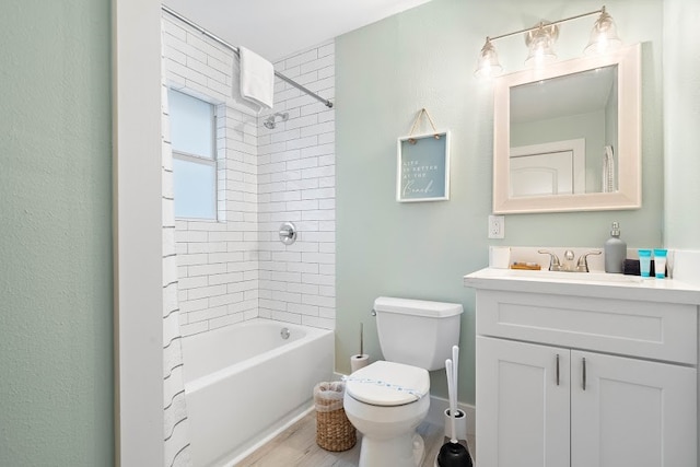 full bathroom with tiled shower / bath, toilet, and vanity