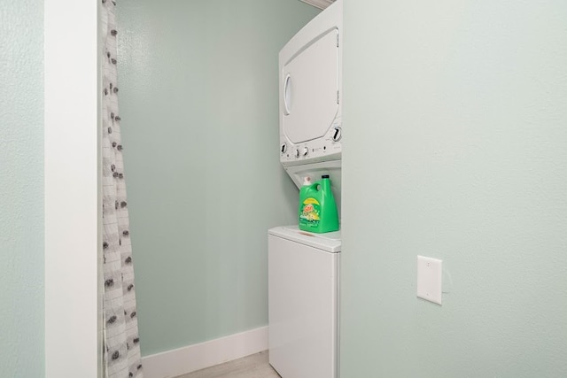 washroom with stacked washing maching and dryer