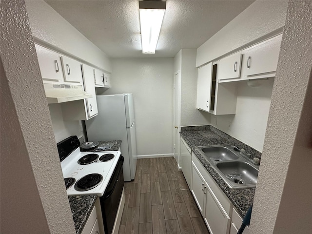 kitchen with dark stone counters, a textured ceiling, white range with electric stovetop, sink, and white cabinets