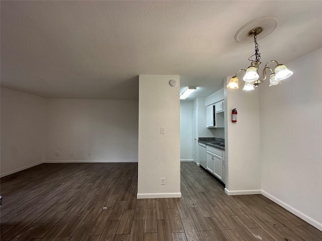 kitchen featuring sink, pendant lighting, a notable chandelier, dark hardwood / wood-style floors, and white cabinetry