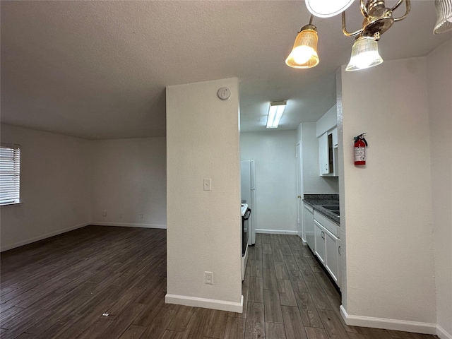 kitchen featuring sink, dark hardwood / wood-style floors, white electric stove, a chandelier, and white cabinets