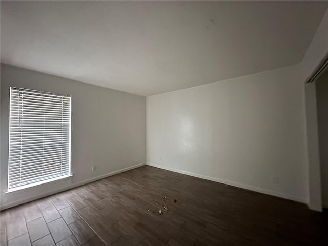 spare room with dark wood-type flooring