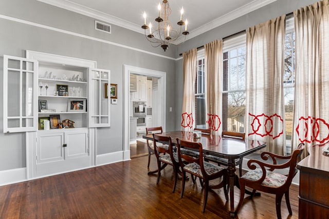 dining room with ornamental molding, dark hardwood / wood-style flooring, and an inviting chandelier