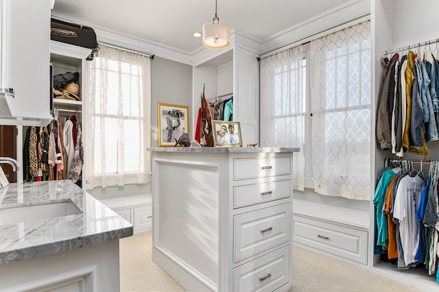 spacious closet featuring light colored carpet and sink