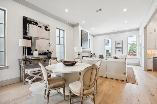 dining space with light wood-style flooring, ornamental molding, and recessed lighting