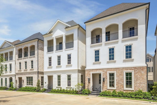 townhome / multi-family property with stucco siding and brick siding