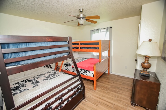 bedroom featuring a textured ceiling, ceiling fan, and light wood-type flooring