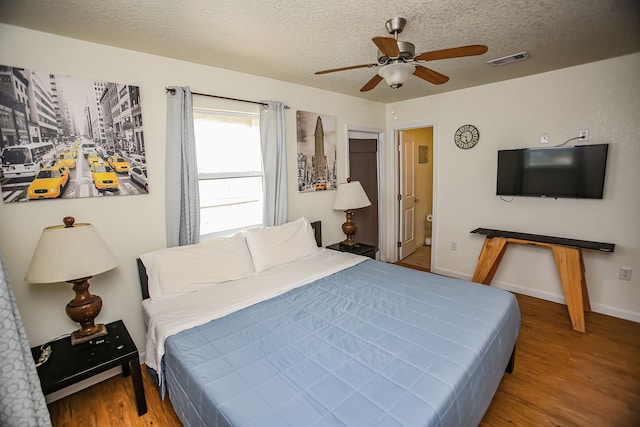 bedroom featuring a textured ceiling, ensuite bath, ceiling fan, and light wood-type flooring