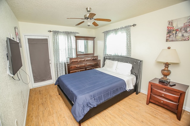 bedroom featuring a textured ceiling, ceiling fan, and light wood-type flooring