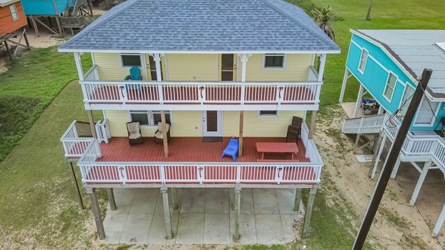 rear view of property with a wooden deck and a lawn