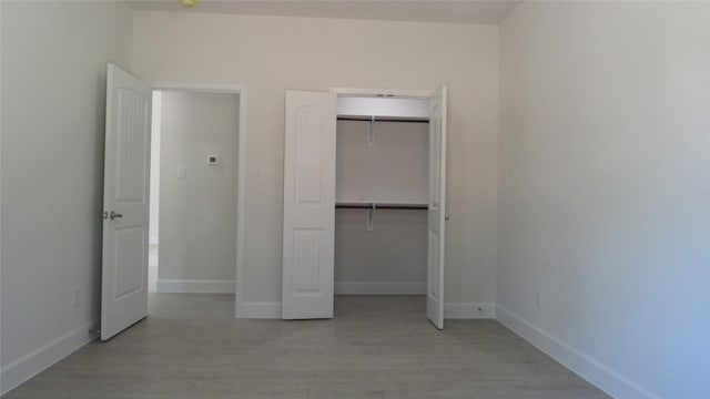 unfurnished bedroom featuring a closet and light hardwood / wood-style floors