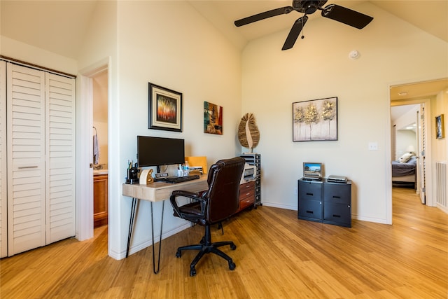 office space with ceiling fan, light hardwood / wood-style flooring, and high vaulted ceiling