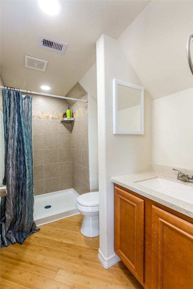 bathroom featuring hardwood / wood-style flooring, a shower with shower curtain, vanity, and toilet