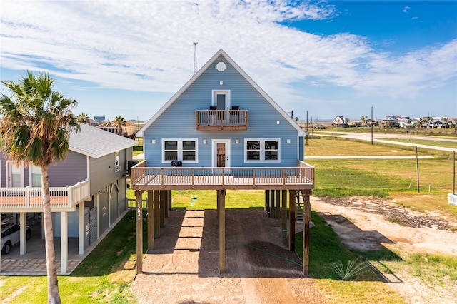 rear view of property featuring a lawn, a balcony, and a patio area