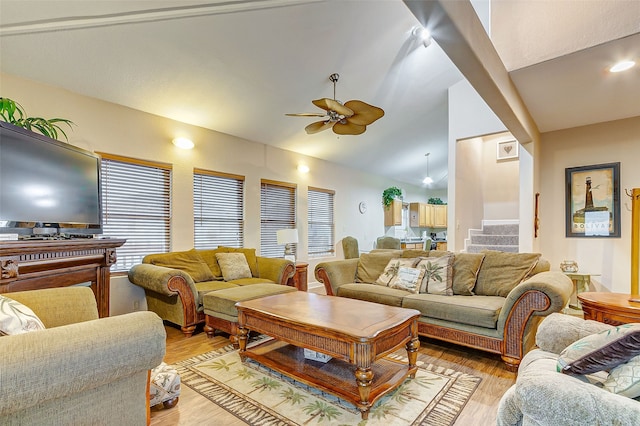 living room with lofted ceiling, ceiling fan, and light hardwood / wood-style flooring