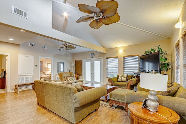 living room with ceiling fan, light wood-type flooring, high vaulted ceiling, and french doors