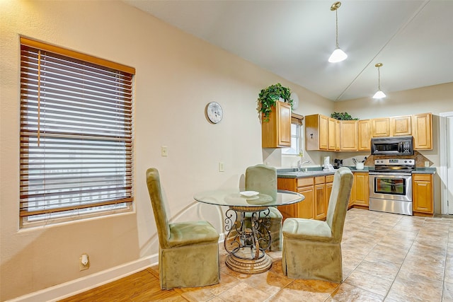 kitchen featuring stainless steel electric range, sink, light tile floors, and decorative light fixtures