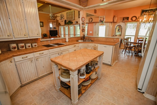 kitchen featuring a notable chandelier, light tile floors, a kitchen island, and white appliances