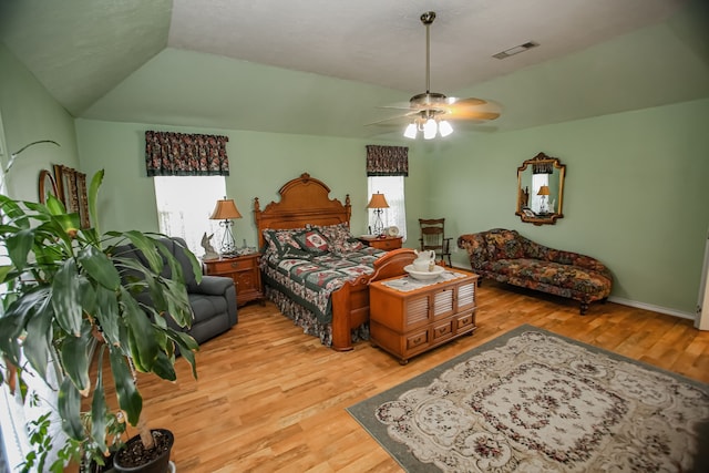 bedroom featuring multiple windows, ceiling fan, vaulted ceiling, and light hardwood / wood-style flooring