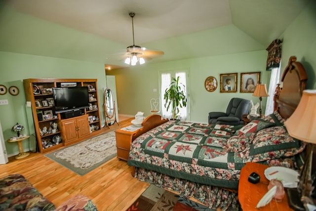bedroom with vaulted ceiling, ceiling fan, and light wood-type flooring