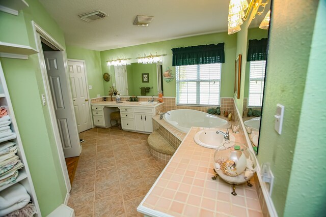 bathroom with tiled bath, vanity, and tile flooring