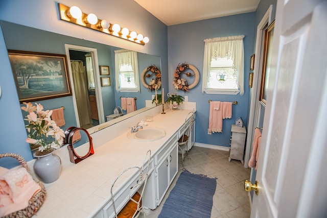 bathroom featuring a healthy amount of sunlight, tile floors, and vanity