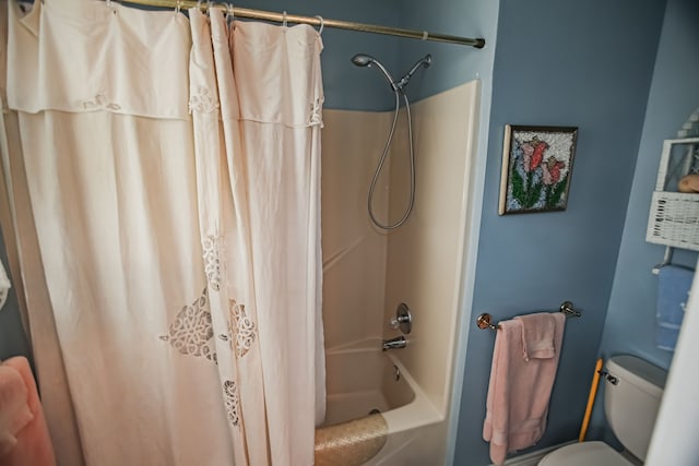 bathroom featuring shower / bath combination with curtain and toilet