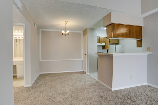 kitchen featuring light carpet, a textured ceiling, decorative light fixtures, and white refrigerator