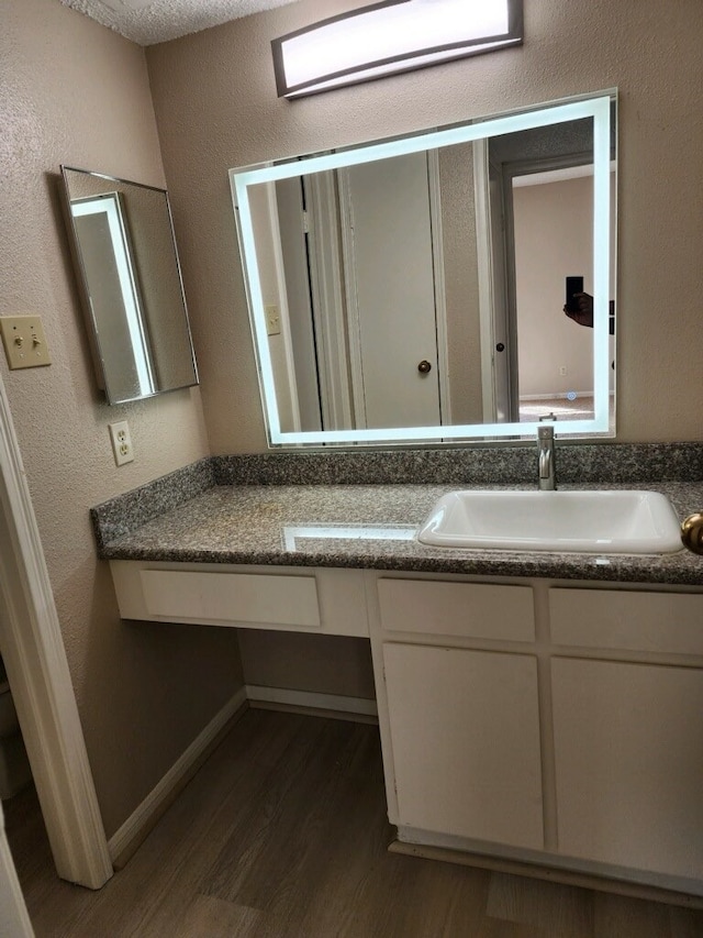 bathroom with vanity, a textured ceiling, and hardwood / wood-style floors