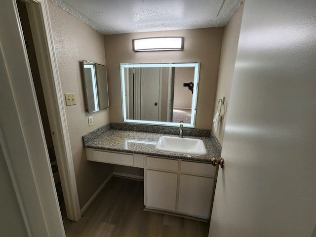 bathroom featuring vanity, hardwood / wood-style floors, and a textured ceiling