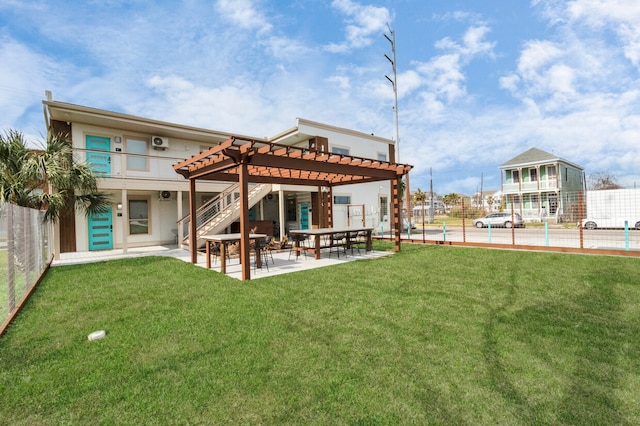 rear view of property featuring a yard, a pergola, and a patio