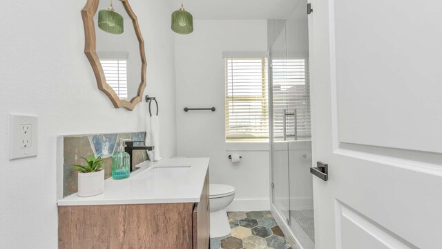 bathroom with tile flooring, toilet, vanity, and a shower with door