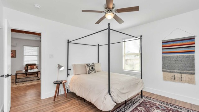 bedroom with multiple windows, ceiling fan, and light hardwood / wood-style flooring